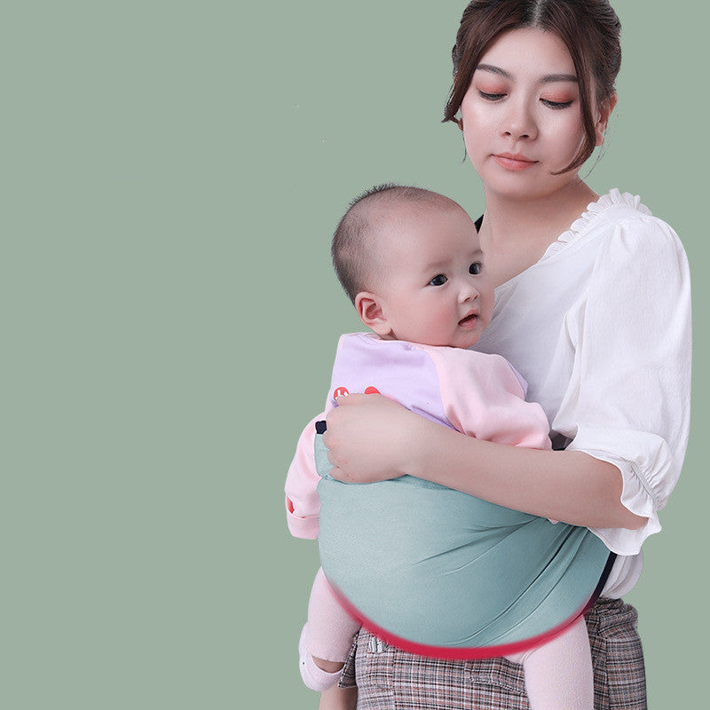 Mother carrying baby in a soft green cotton baby sling wrap for comfortable hands-free support