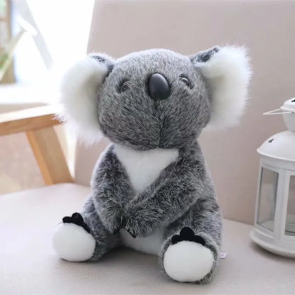 Soft grey and white koala plush toy for kids with fluffy ears and black nose sitting on a chair